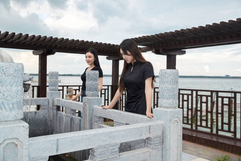 盛夏在景区湖边许愿井祈福的美女