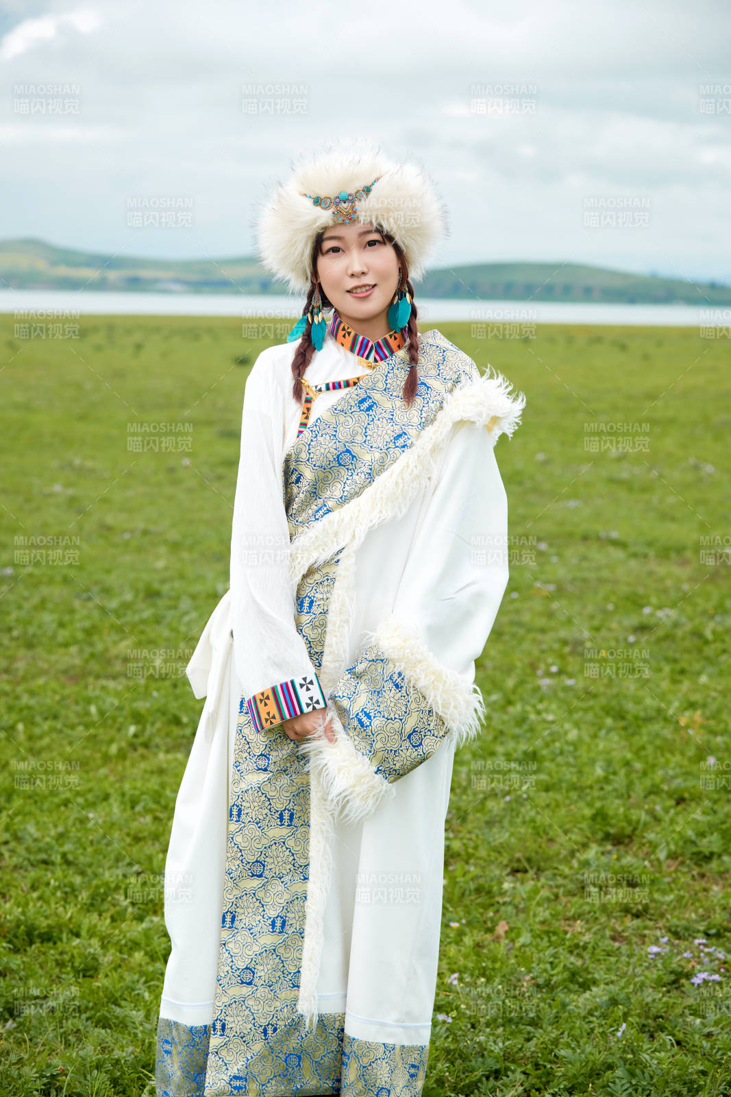 穿白色藏族服饰在草原拍照的少女