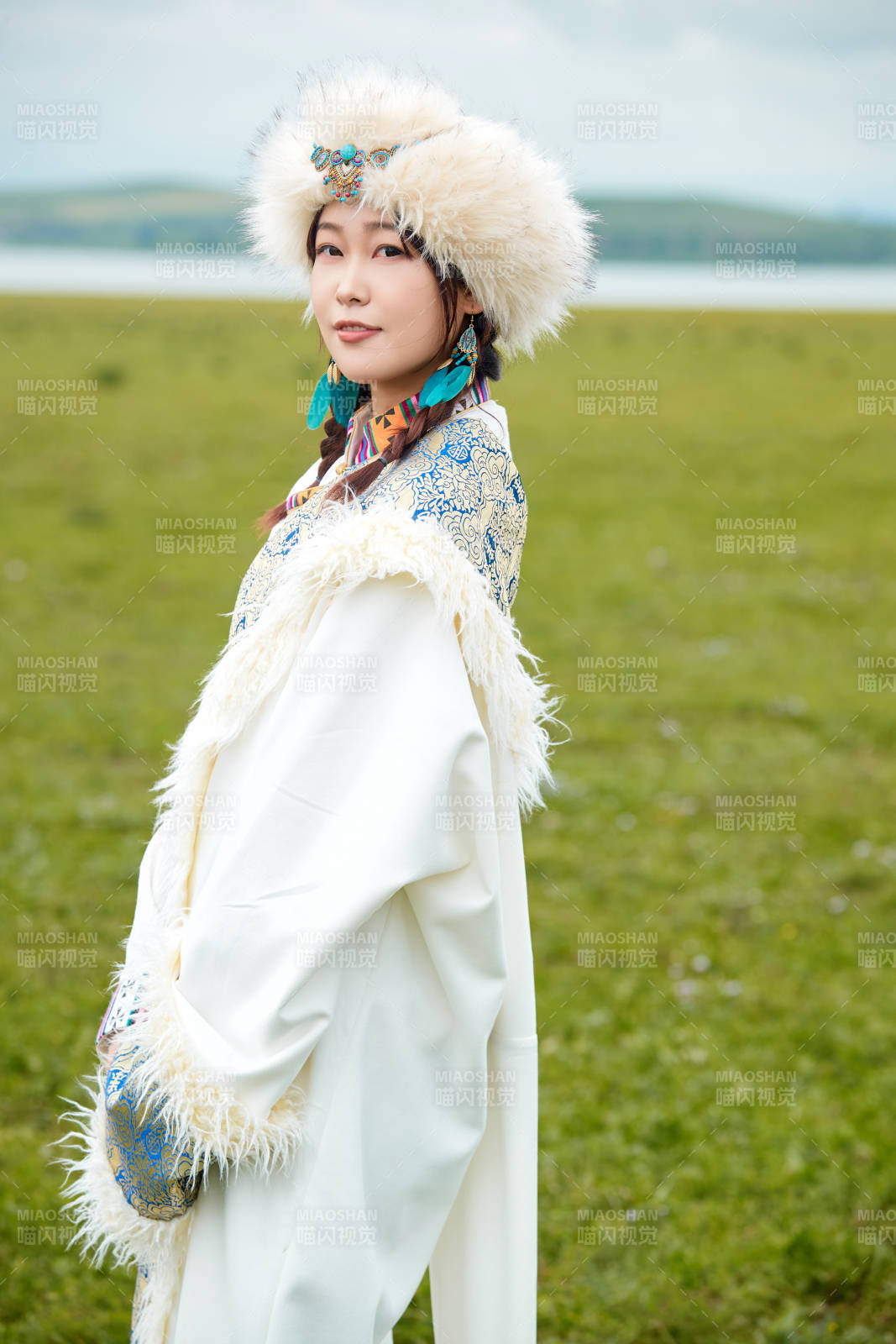 穿白色藏族服饰在草原拍照的少女