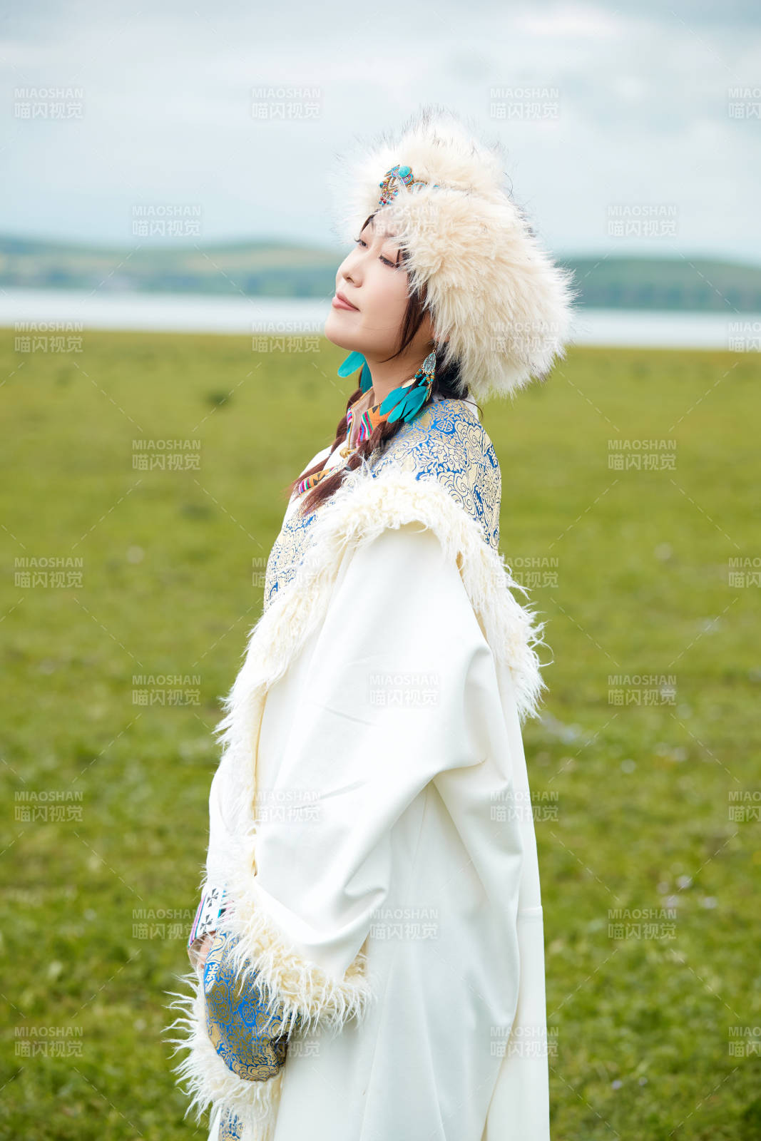 穿白色藏族服饰在草原拍照的少女