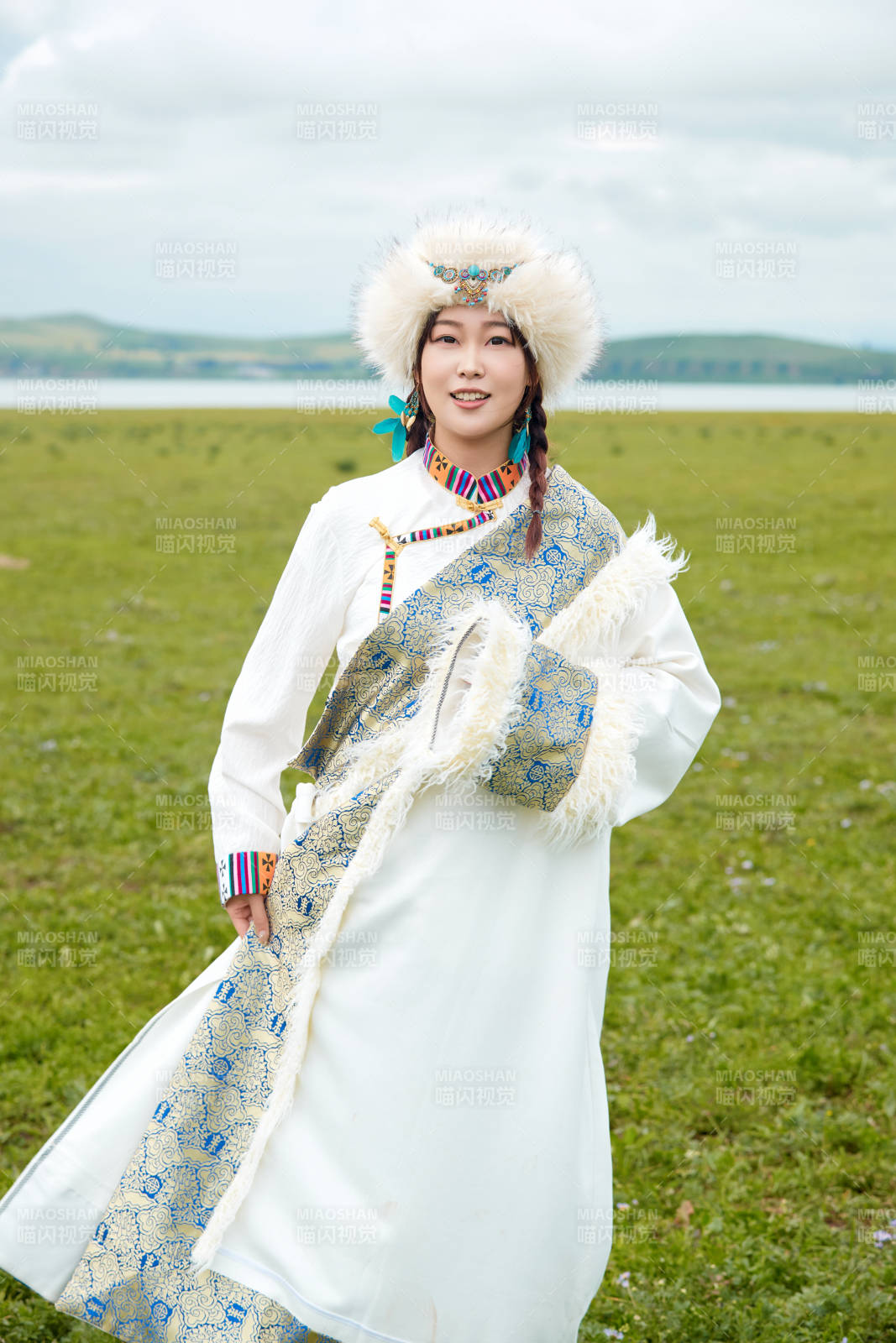 穿白色藏族服飾在草原拍照的少女