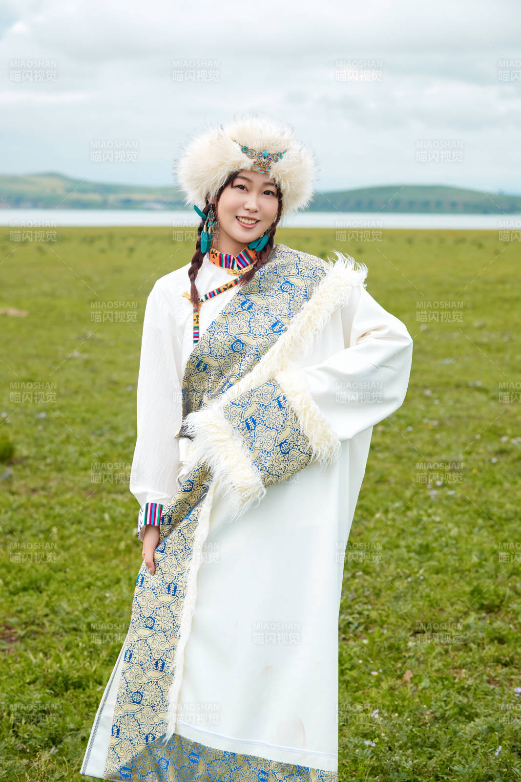 穿白色藏族服飾在草原拍照的少女