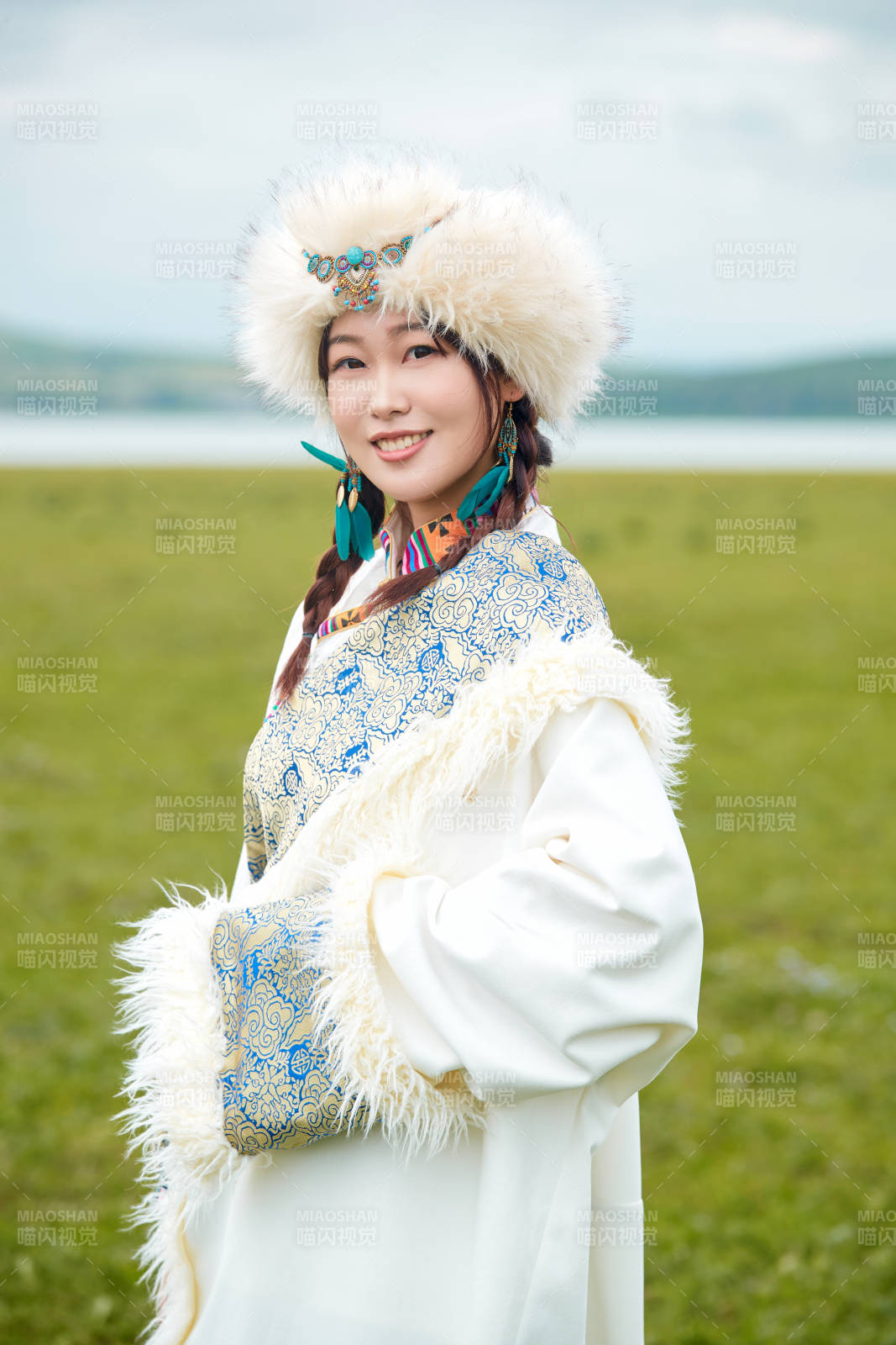 穿白色藏族服飾在草原拍照的少女