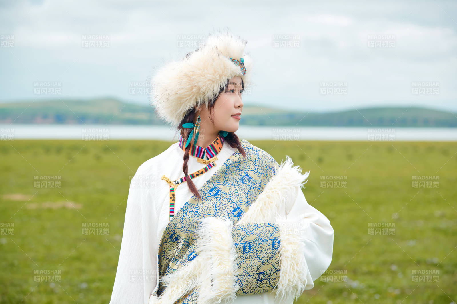 穿白色藏族服飾在草原拍照的少女