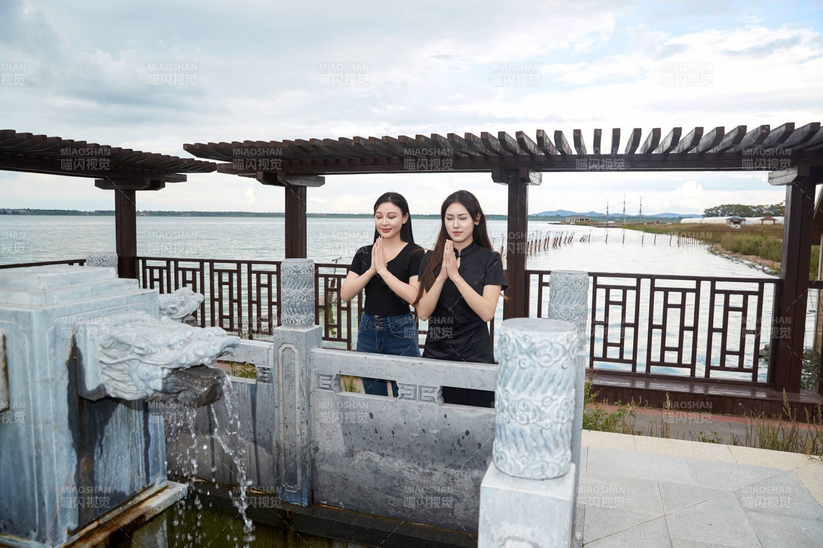 盛夏在景区湖边许愿井祈福的美女