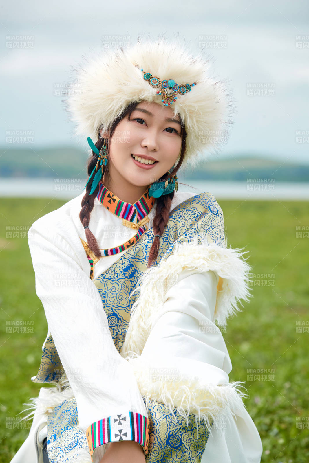 穿白色藏族服饰在草原拍照的少女