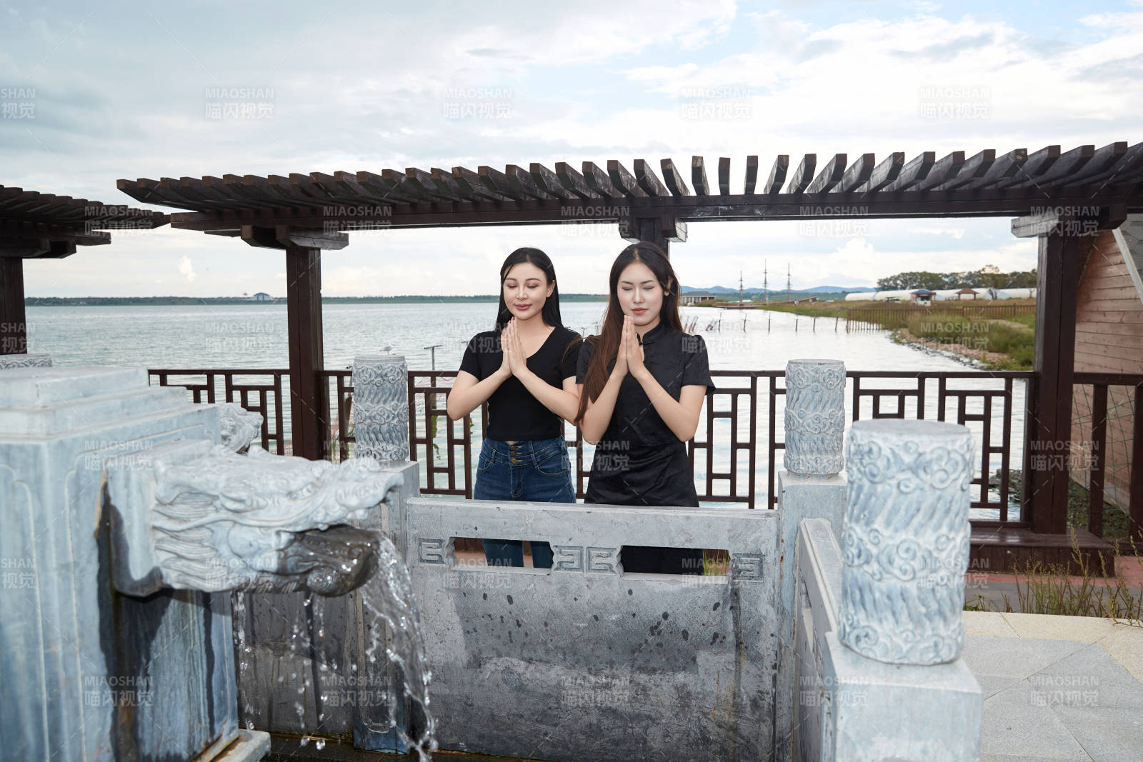 盛夏在景区湖边许愿井祈福的美女