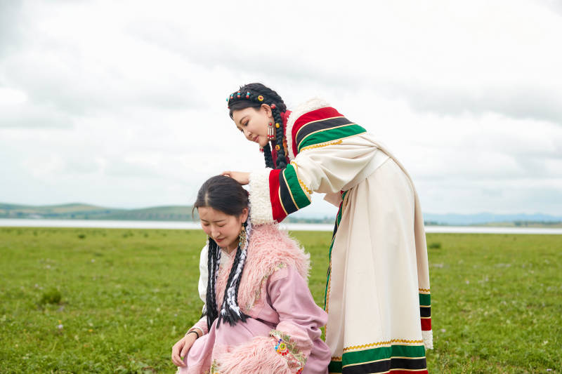 穿藏族服饰在草原拍照游玩的姑娘们