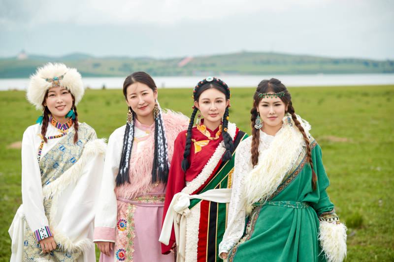 穿藏族服饰在草原拍照游玩的姑娘们