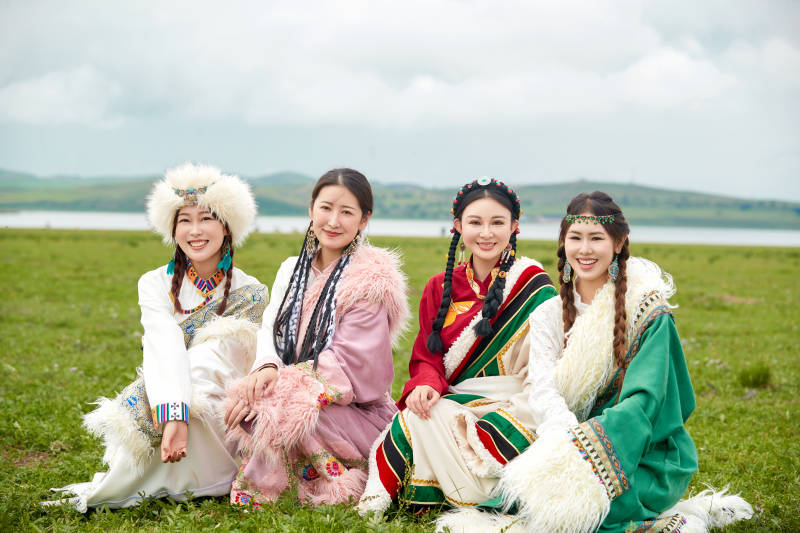 穿藏族服饰在草原拍照游玩的姑娘们