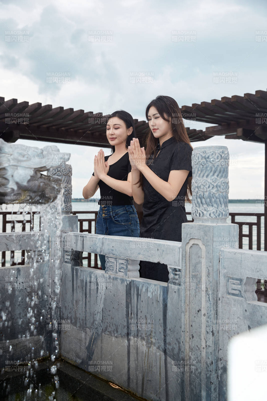 盛夏在景區(qū)湖邊許愿井祈福的美女