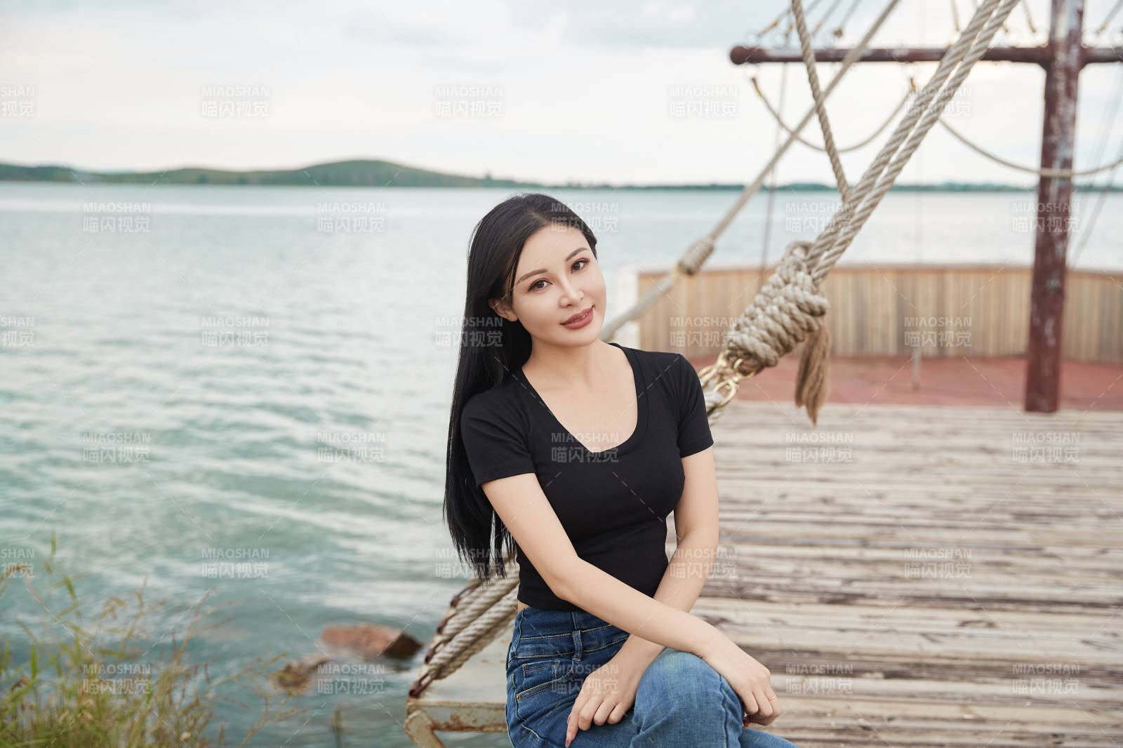 在湖畔木制帆船上拍照游玩的亚洲女性