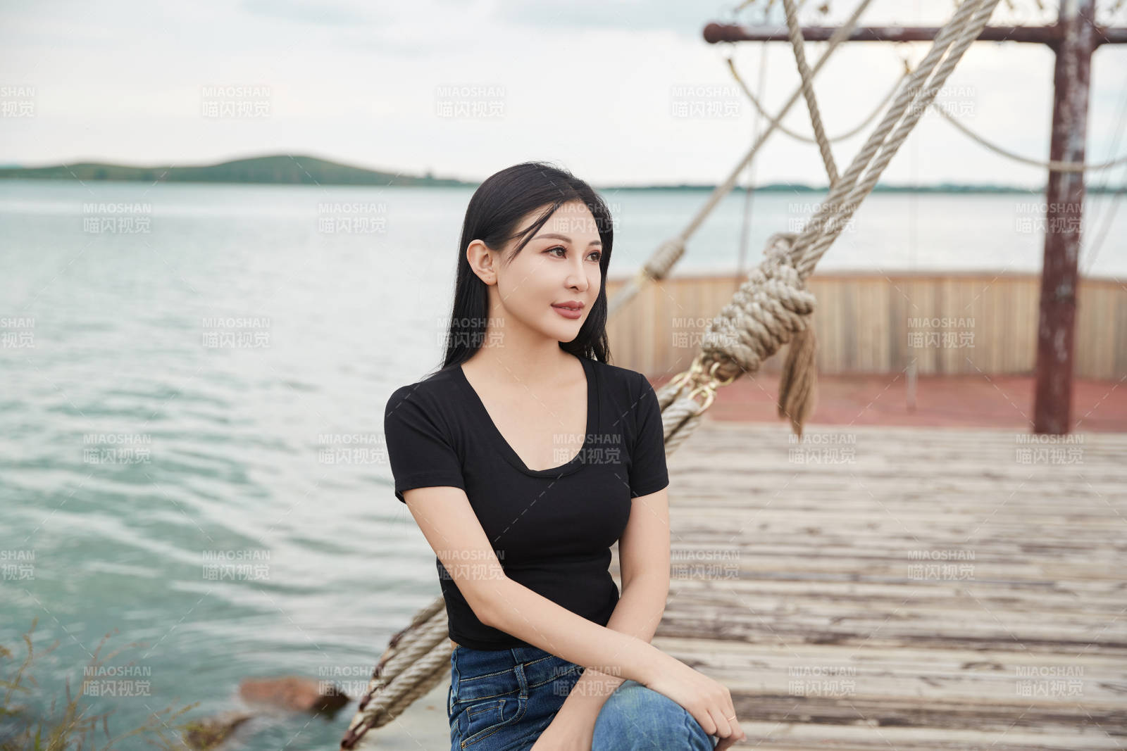 在湖畔木制帆船上拍照游玩的亚洲女性