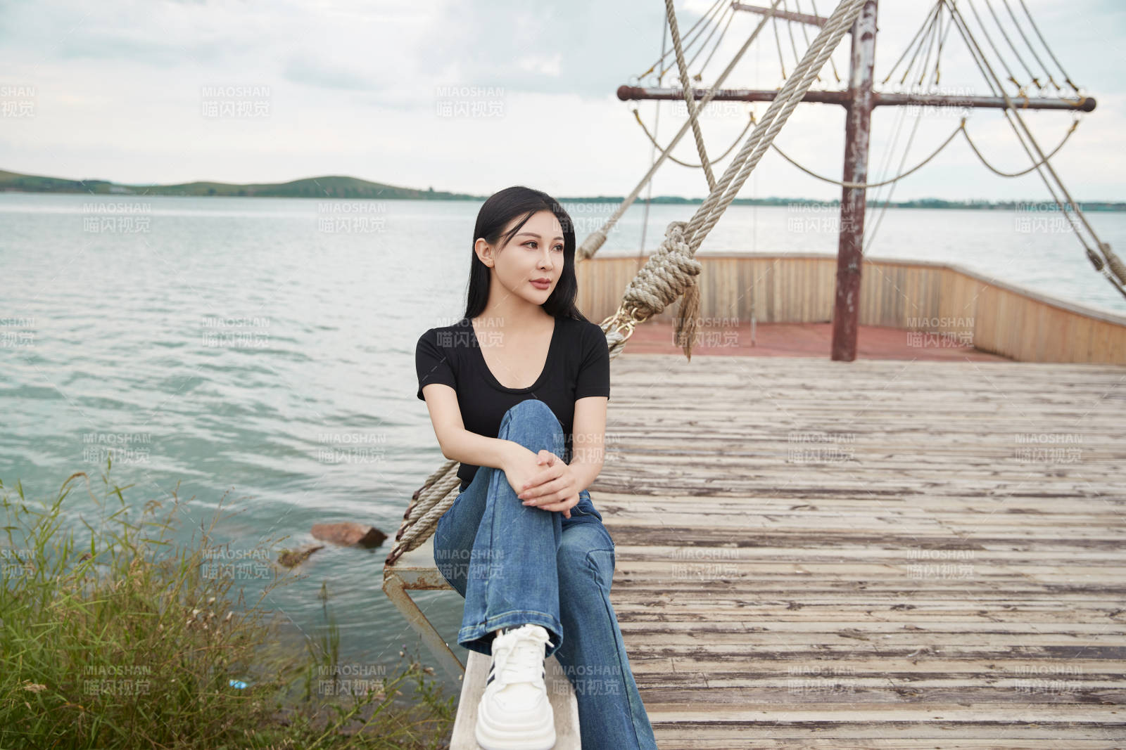 在湖畔木制帆船上拍照游玩的亞洲女性