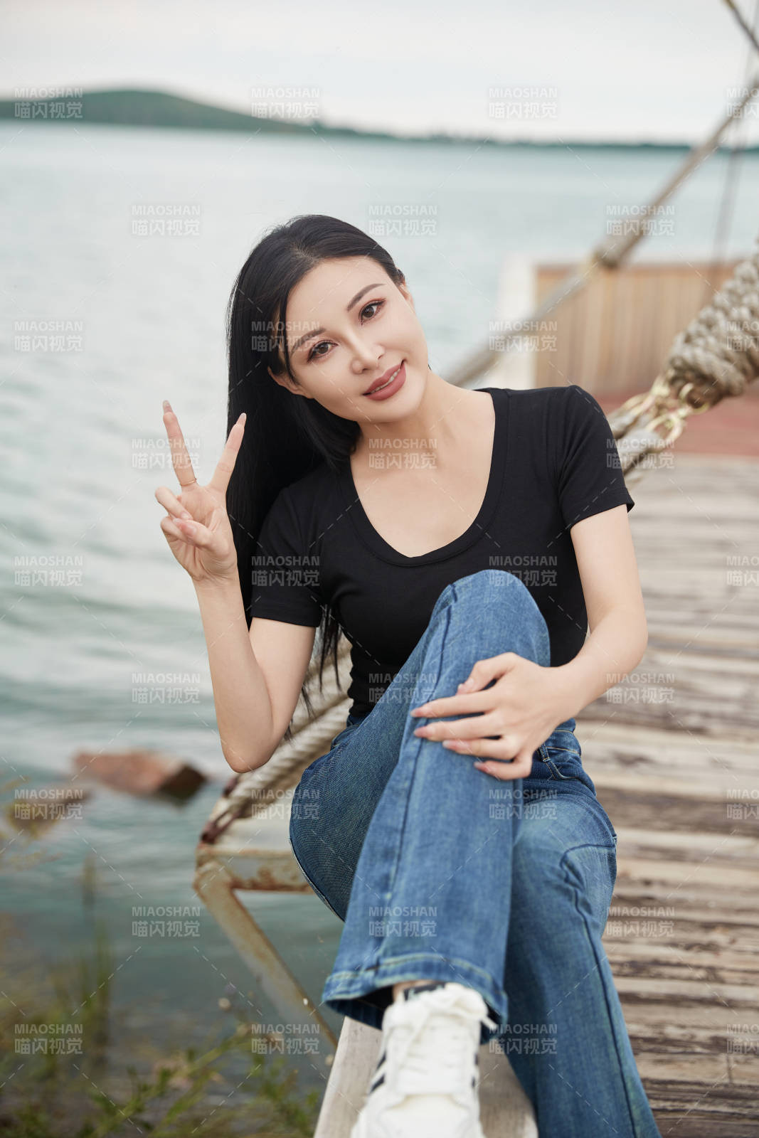 在湖畔木制帆船上拍照游玩的亚洲女性