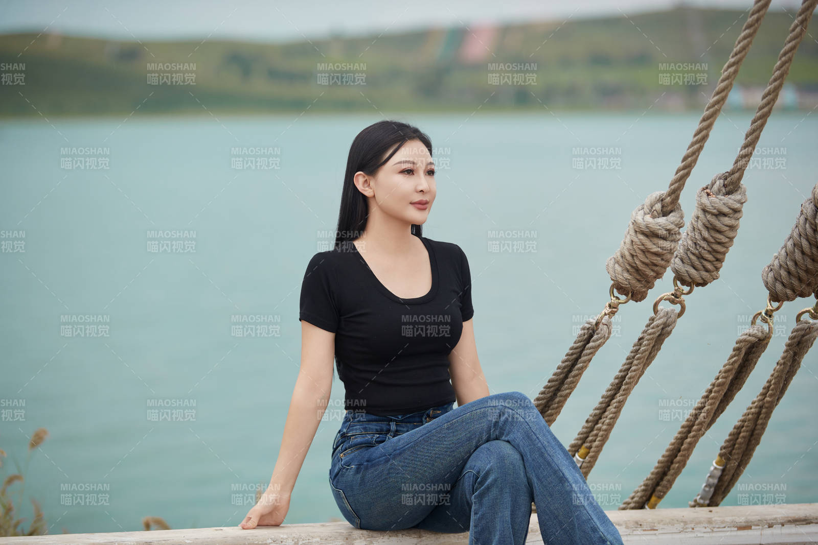 在湖畔木制帆船上拍照游玩的亚洲女性