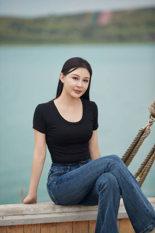 在湖畔木制帆船上拍照游玩的亚洲女性