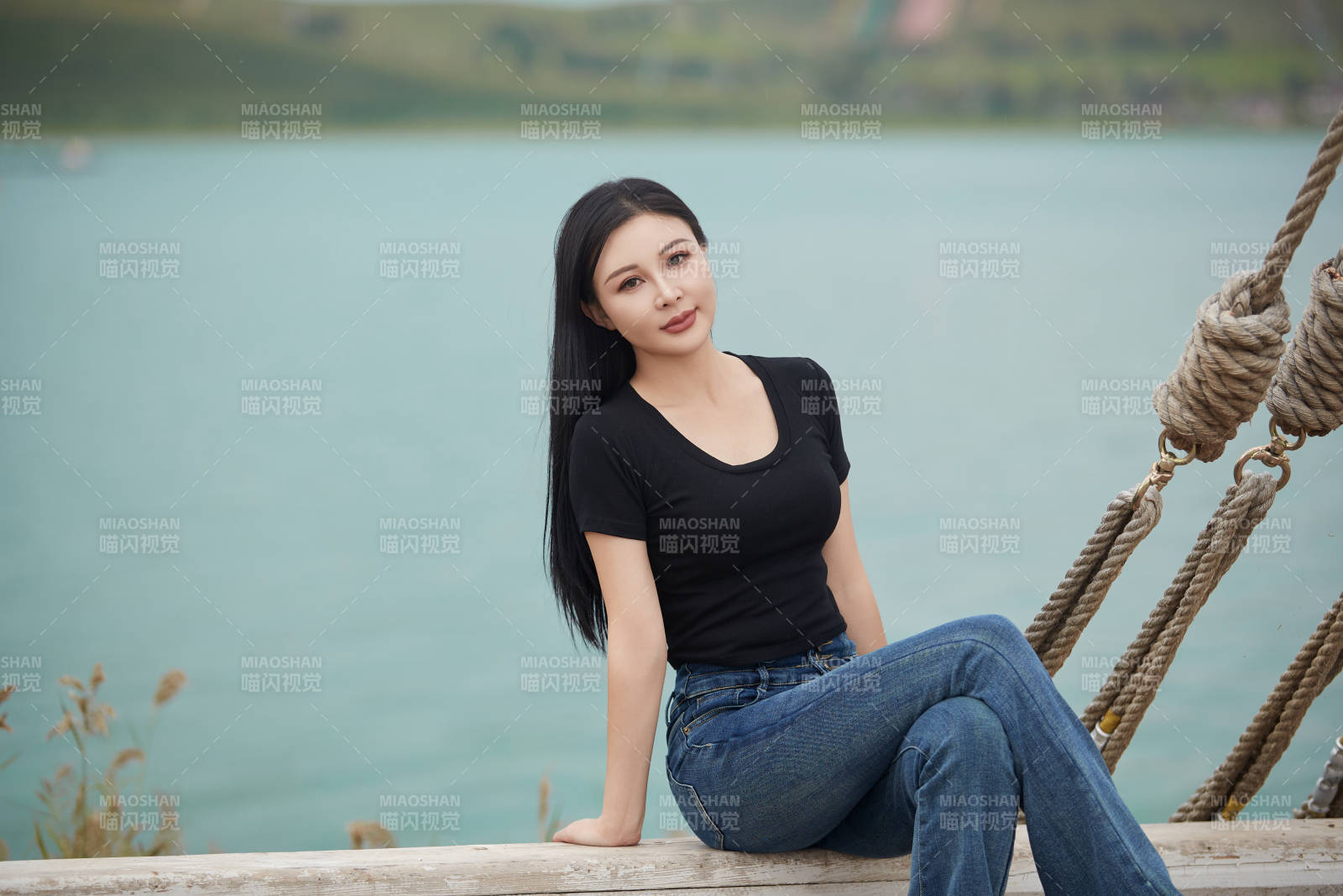 在湖畔木制帆船上拍照游玩的亚洲女性