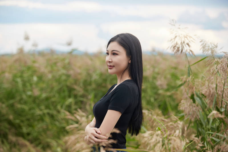 盛夏在草原湿地公园拍照游玩的美女