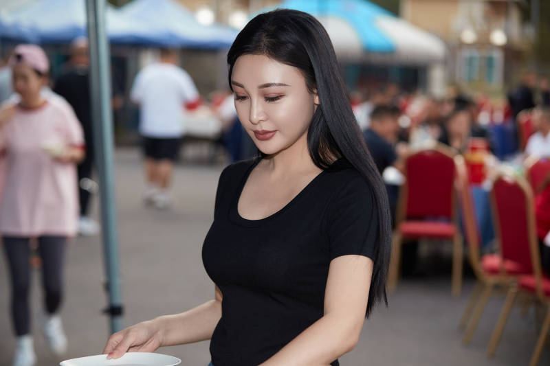 在户外烤全羊自助餐会品尝美食的美女