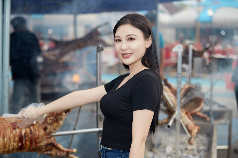 在户外烤全羊自助餐会品尝美食的美女