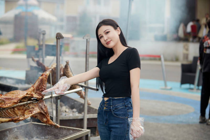 在户外烤全羊自助餐会品尝美食的美女