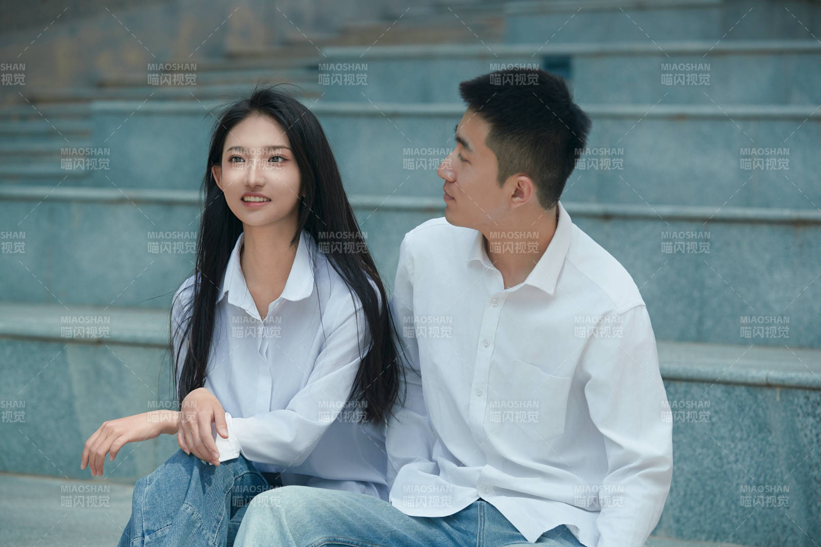 坐在戶外臺(tái)階上的青年情侶