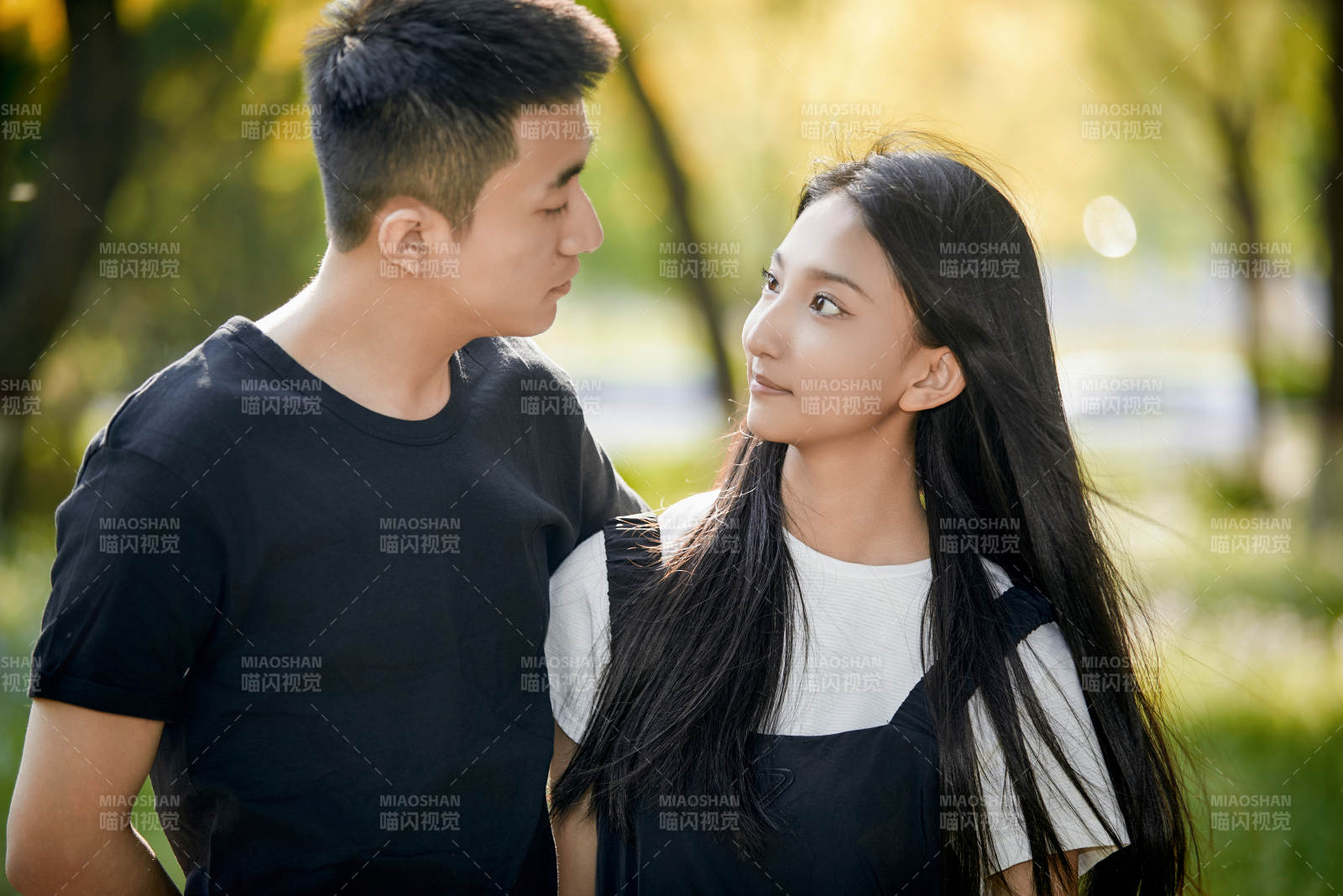 戶外草坪上的恩愛年輕情侶