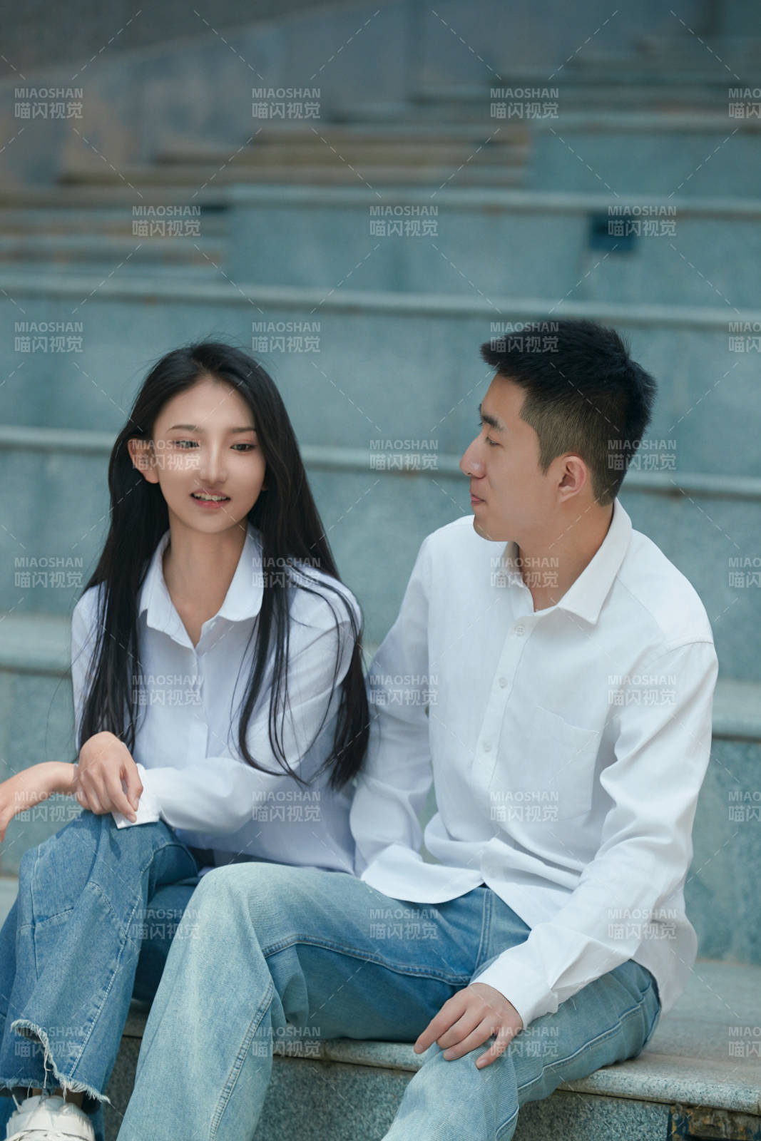 坐在戶外臺階上的青年情侶