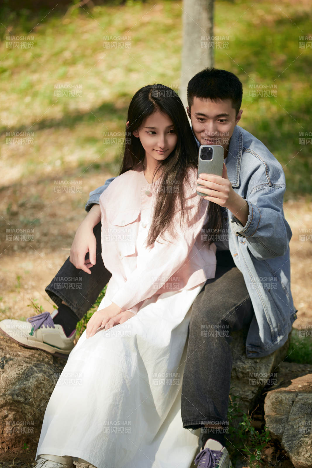 户外公园里用手机自拍的年轻情侣