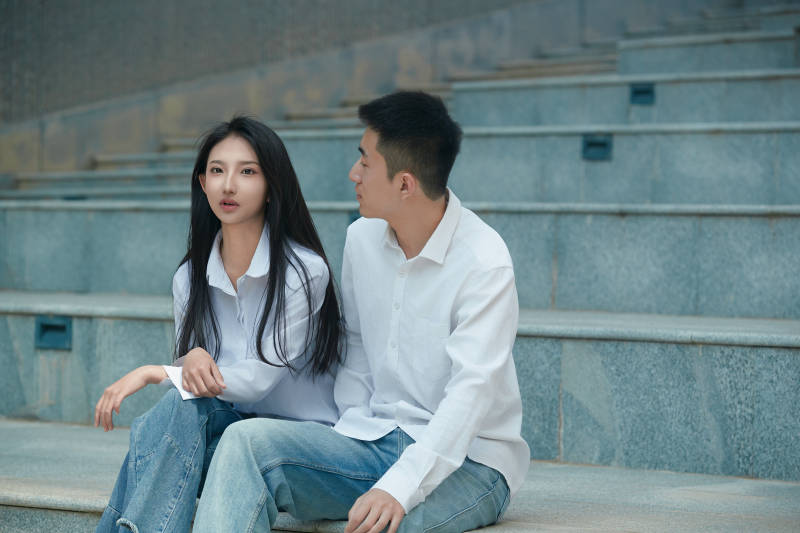 坐在户外台阶上的青年情侣