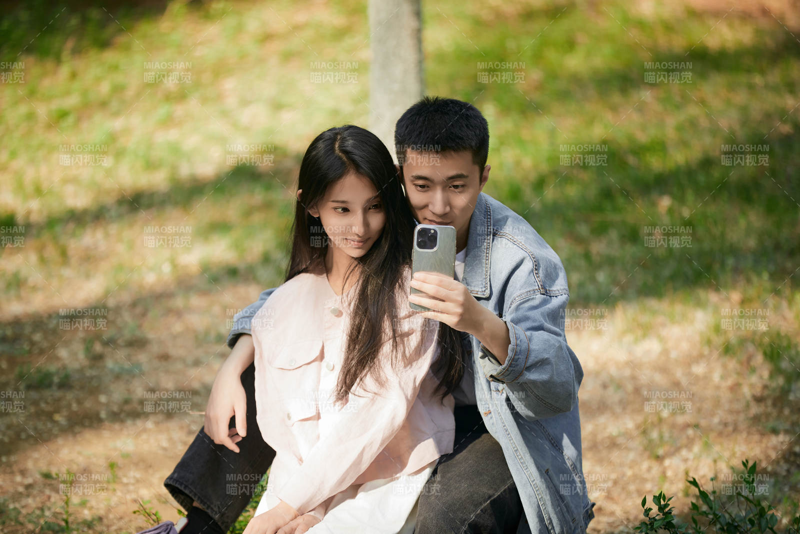 户外公园里用手机自拍的年轻情侣