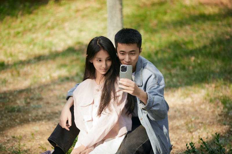 户外公园里用手机自拍的年轻情侣