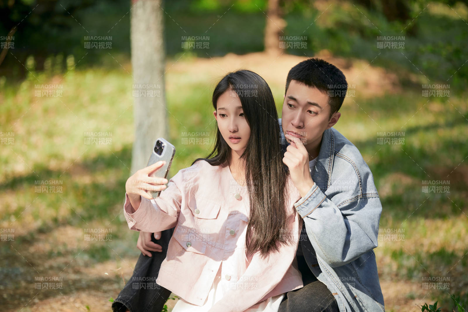戶外公園里用手機自拍的年輕情侶