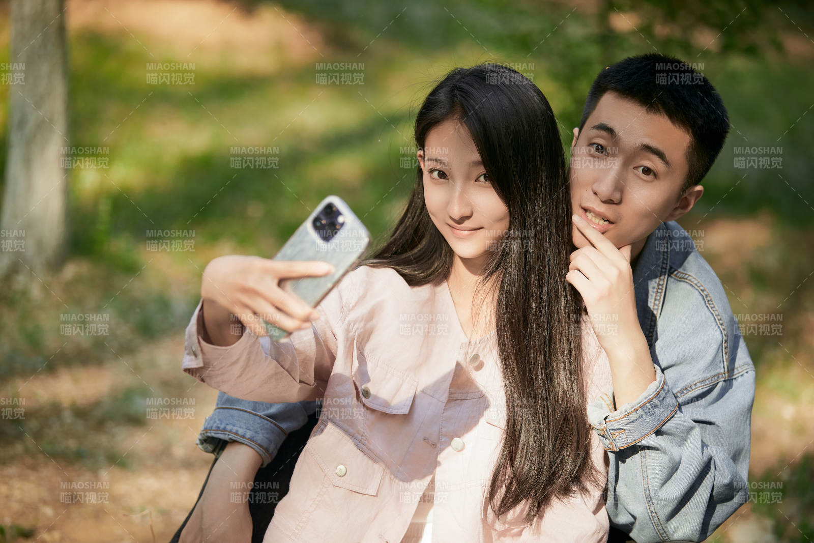 户外公园里用手机自拍的年轻情侣