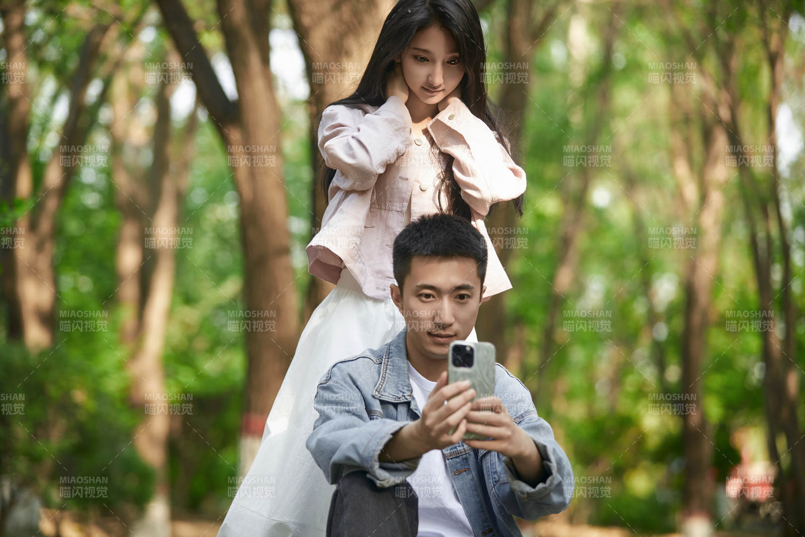 户外公园里用手机自拍的年轻情侣