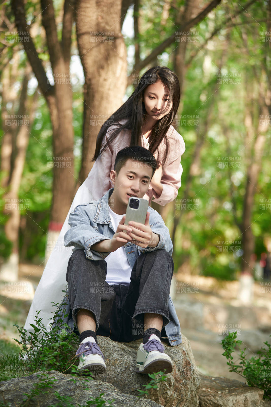 户外公园里用手机自拍的年轻情侣