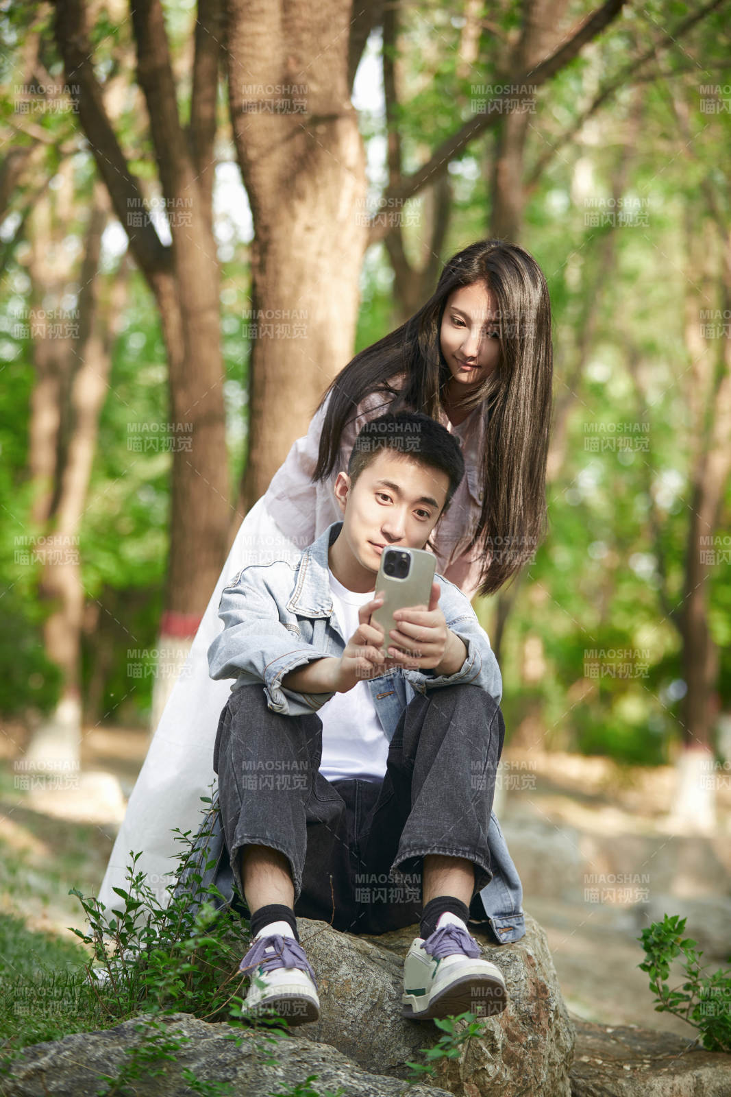 户外公园里用手机自拍的年轻情侣