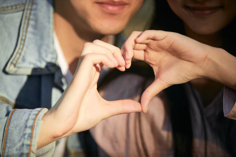 相互用手比爱心表达爱意的情侣