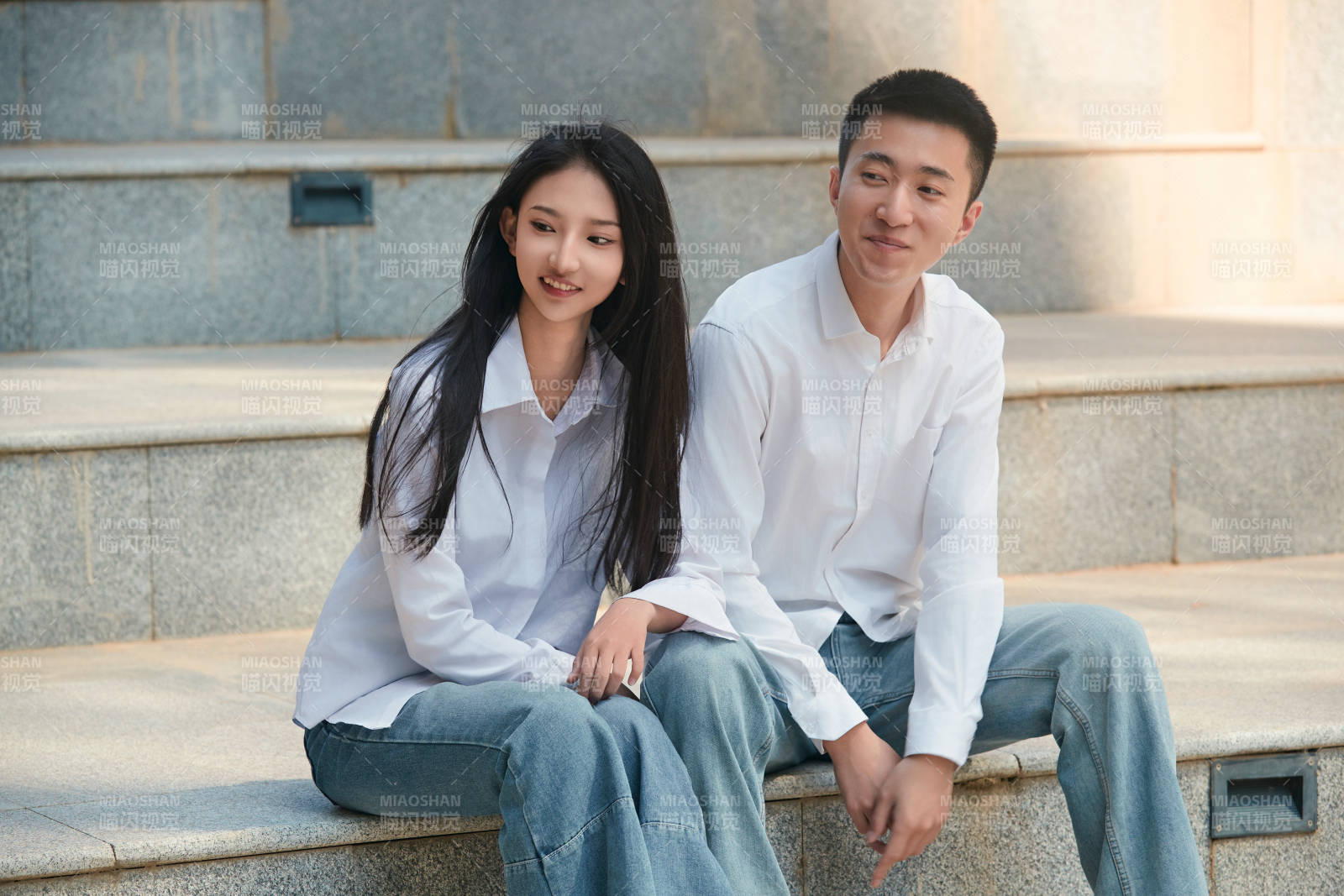 坐在户外台阶上的青年情侣