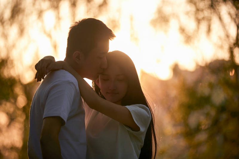 户外在夕阳下的恩爱年轻情侣