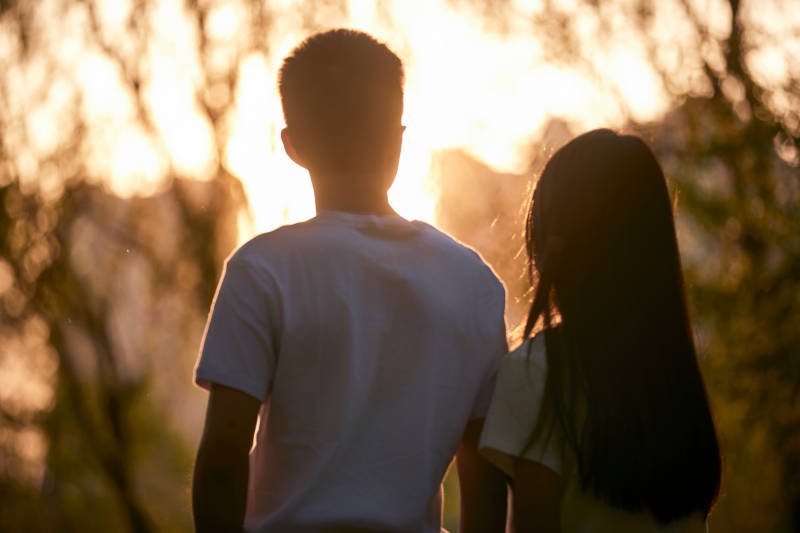 户外在夕阳下的恩爱年轻情侣