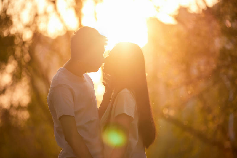 户外在夕阳下的恩爱年轻情侣