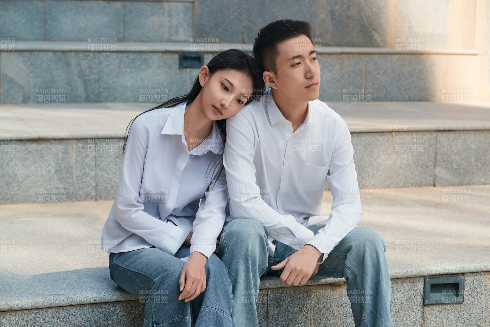 坐在户外台阶上的青年情侣