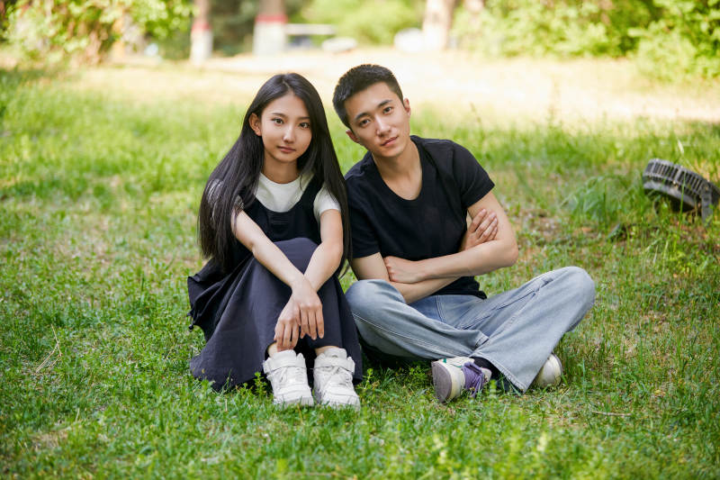 户外草坪上的恩爱年轻情侣