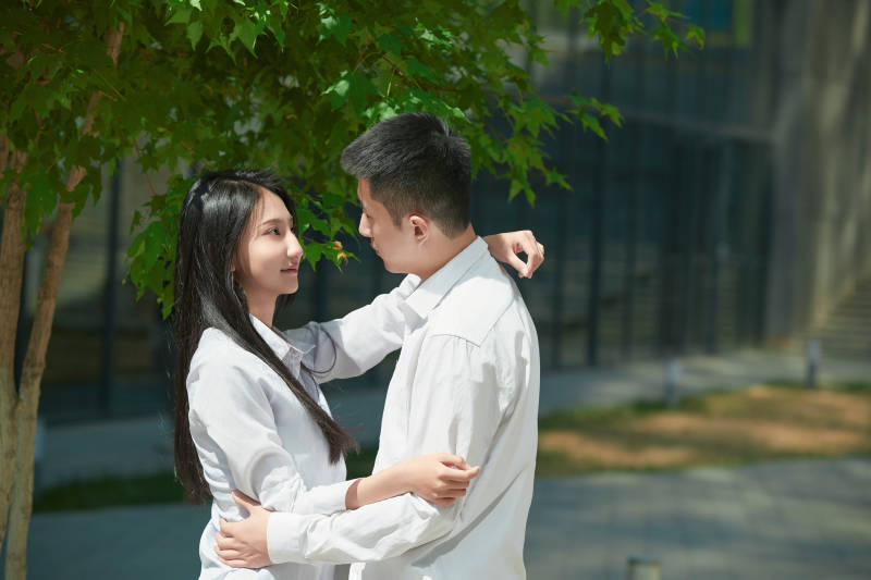 坐在户外台阶上的青年情侣