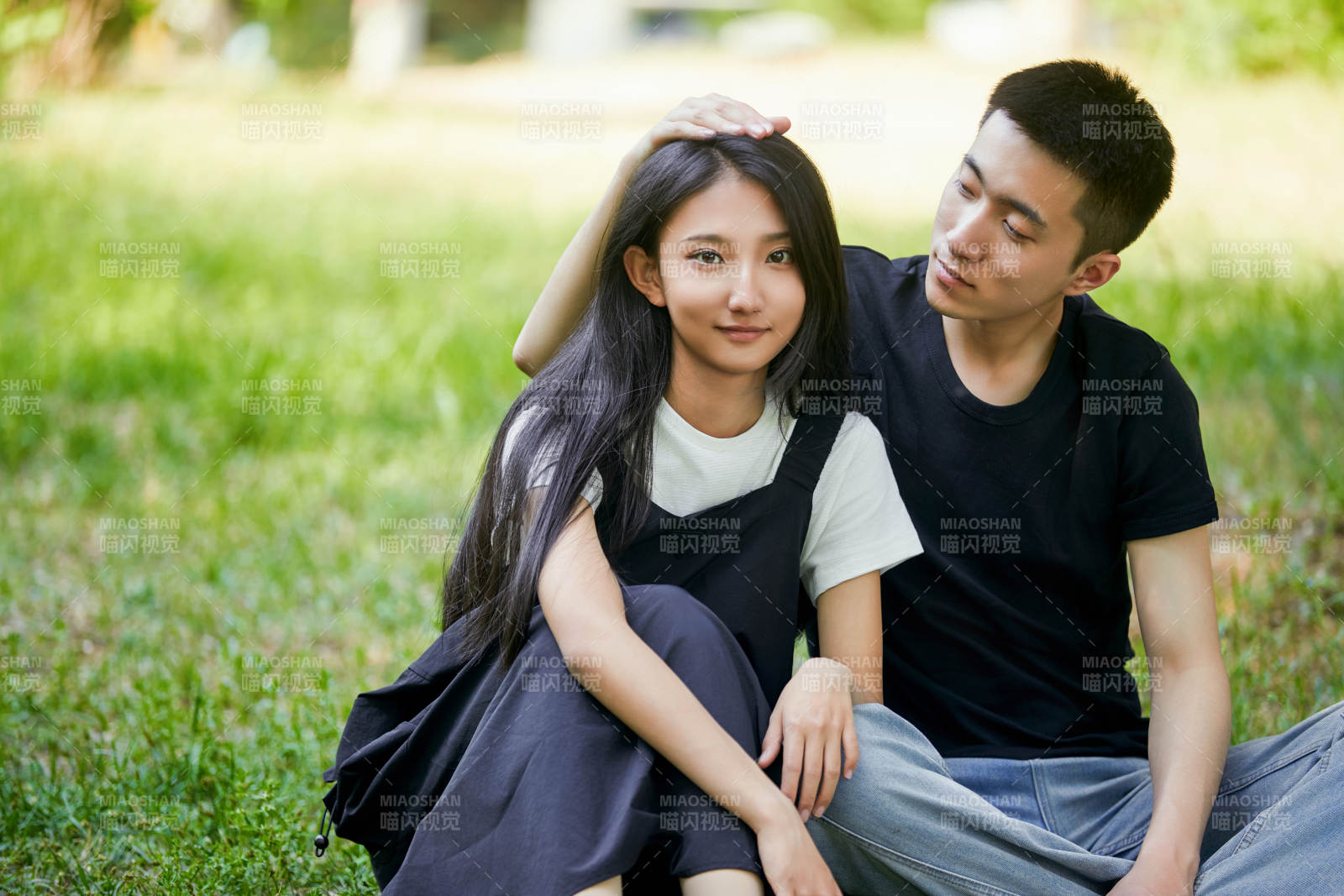 户外草坪上的恩爱年轻情侣