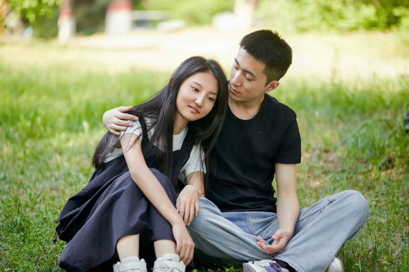 户外草坪上的恩爱年轻情侣