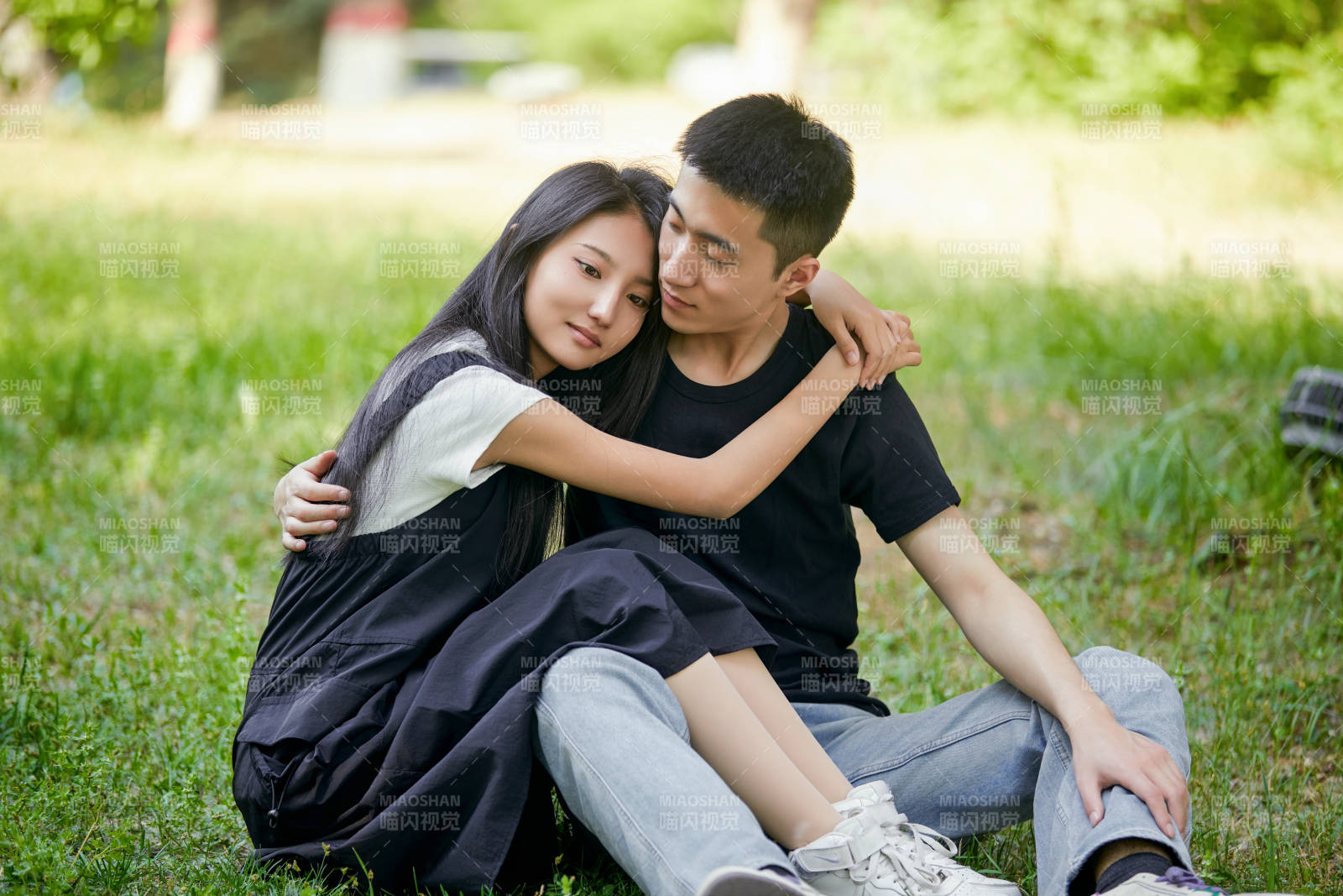 户外草坪上的恩爱年轻情侣