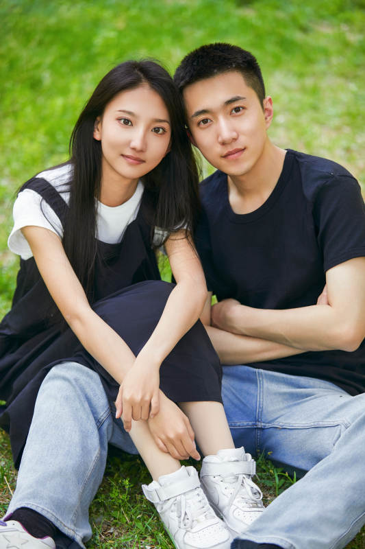 户外草坪上的恩爱年轻情侣